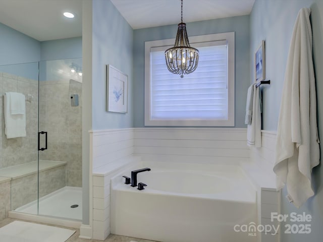 bathroom featuring plus walk in shower and an inviting chandelier