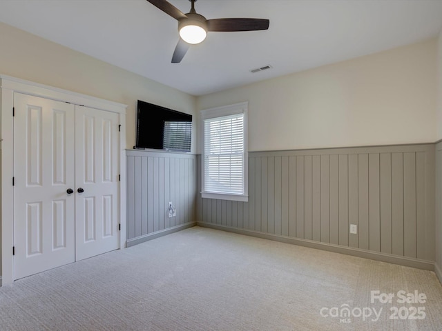 unfurnished room featuring ceiling fan and light colored carpet