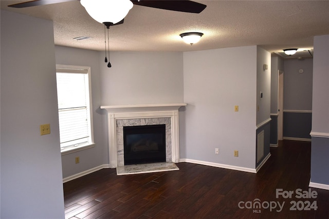 unfurnished living room featuring a fireplace, a textured ceiling, and dark hardwood / wood-style floors