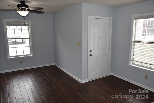 unfurnished room featuring plenty of natural light, ceiling fan, and dark hardwood / wood-style flooring