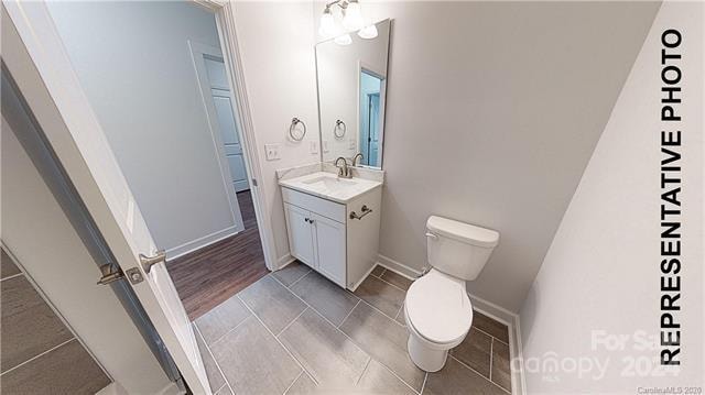 bathroom featuring hardwood / wood-style floors, vanity, and toilet