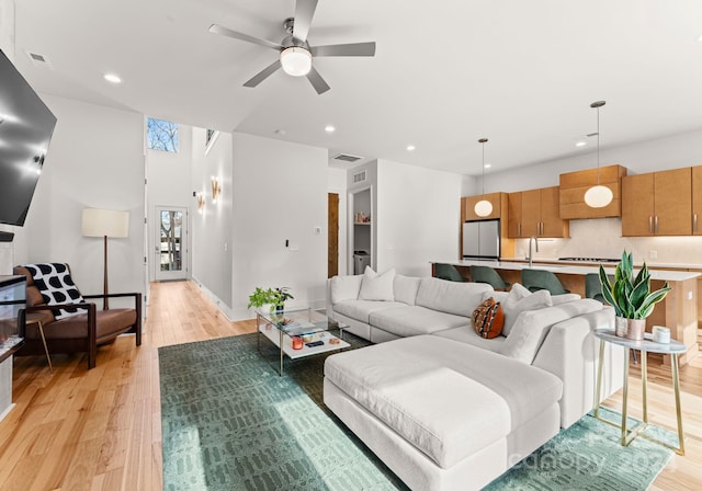 living room with ceiling fan and light hardwood / wood-style flooring