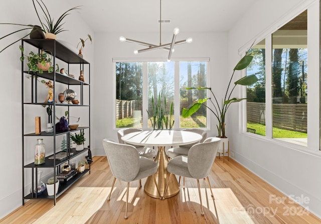 dining area with a chandelier and light hardwood / wood-style flooring