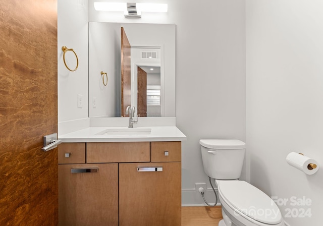 bathroom featuring vanity, hardwood / wood-style flooring, and toilet