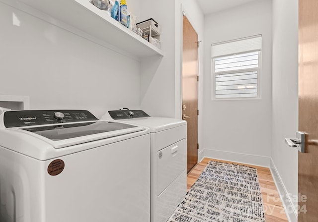 clothes washing area with separate washer and dryer and light hardwood / wood-style floors