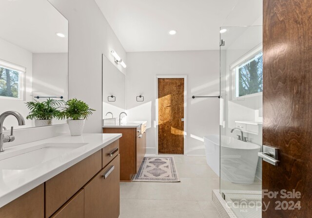 bathroom with tile patterned flooring, vanity, and shower with separate bathtub