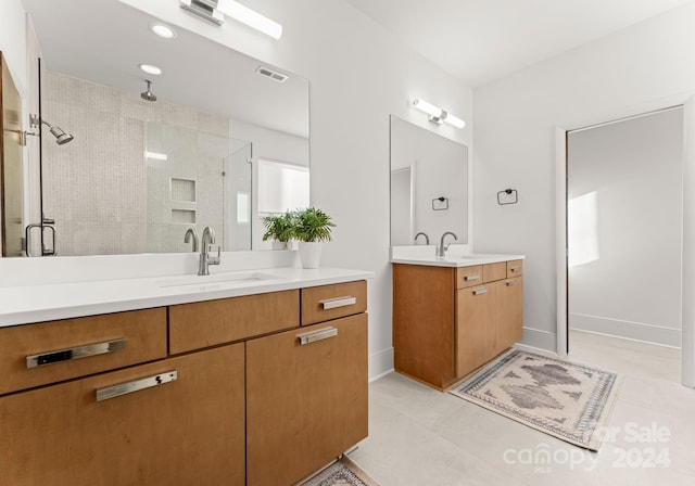 bathroom with tile patterned flooring, vanity, and a shower with door