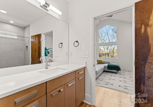 bathroom featuring a tile shower, hardwood / wood-style floors, and vanity