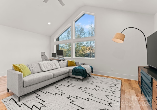 living room featuring ceiling fan, lofted ceiling, and light wood-type flooring