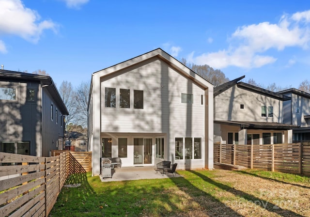 rear view of property with a patio area and a lawn