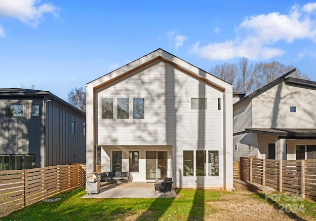 rear view of property with a yard and a patio