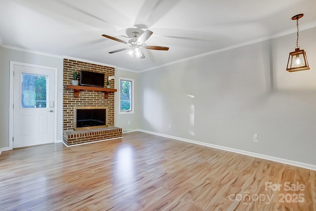 unfurnished living room with light wood-type flooring, a brick fireplace, ceiling fan, and crown molding