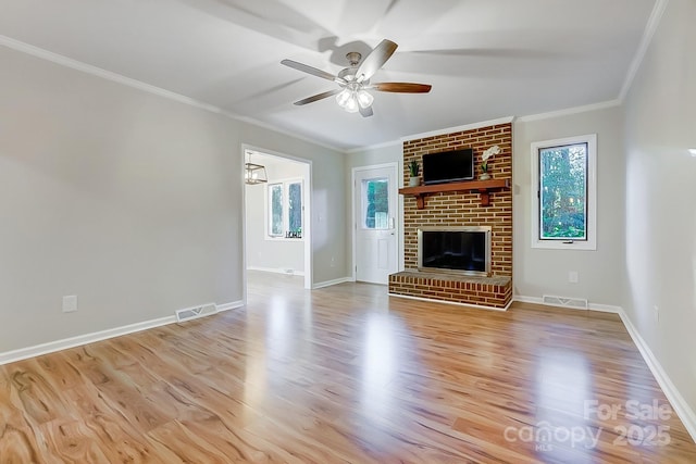 unfurnished living room featuring light hardwood / wood-style floors, a brick fireplace, ceiling fan, and ornamental molding