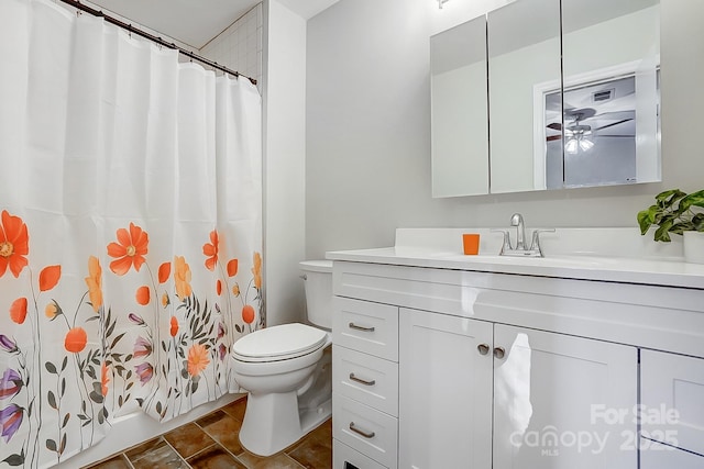 bathroom featuring walk in shower, ceiling fan, vanity, and toilet