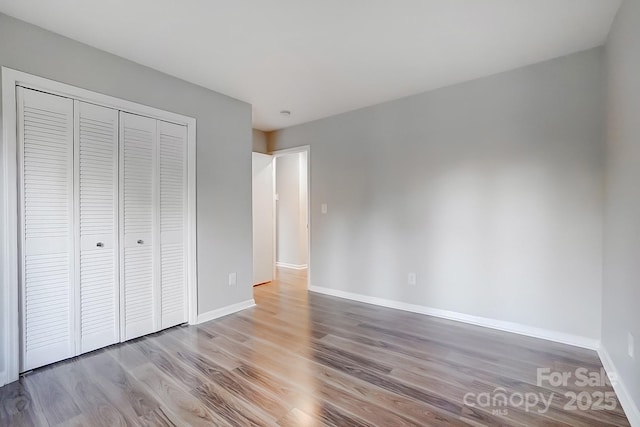 unfurnished bedroom featuring light wood-type flooring and a closet