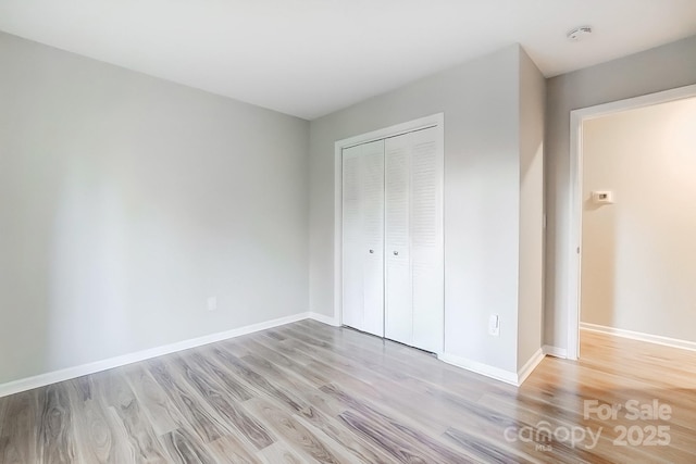 unfurnished bedroom with light hardwood / wood-style floors and a closet