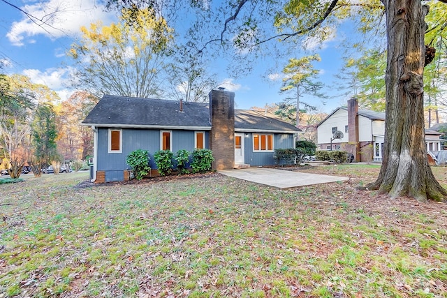 rear view of house with a yard and a patio