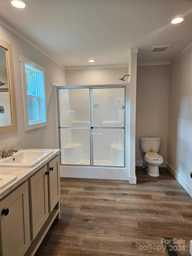 bathroom with vanity, wood-type flooring, walk in shower, and ornamental molding