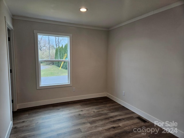 empty room with crown molding and dark hardwood / wood-style flooring