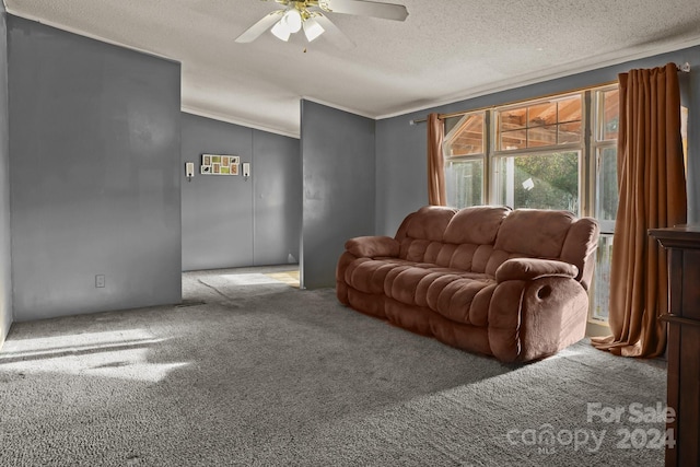 living room featuring carpet, ceiling fan, ornamental molding, and a textured ceiling