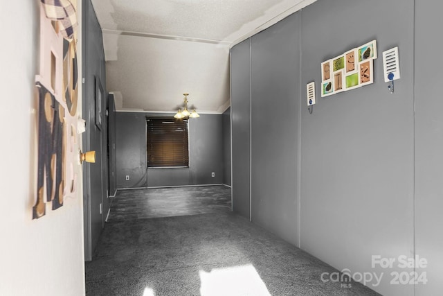 hallway featuring a textured ceiling, lofted ceiling, and ornamental molding