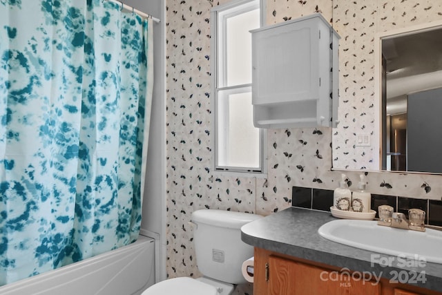 full bathroom featuring shower / bath combo with shower curtain, vanity, and toilet