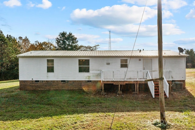 back of house with a lawn and a deck