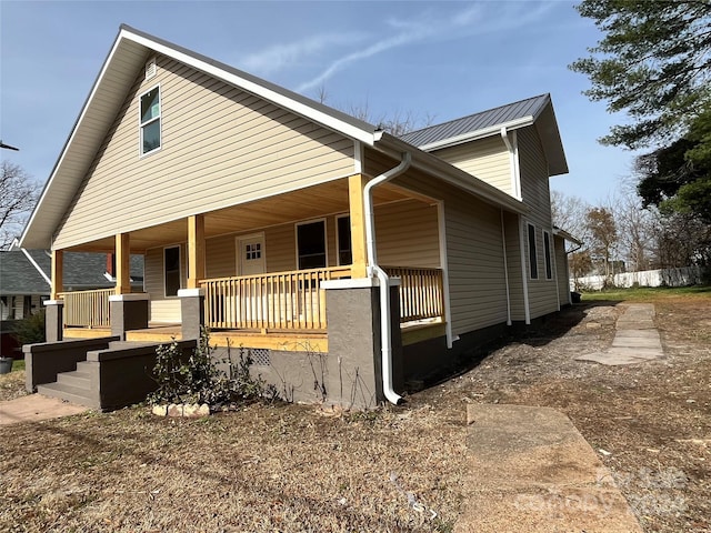 view of side of property featuring covered porch