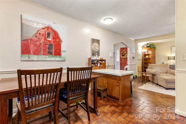 dining room with crown molding and a textured ceiling