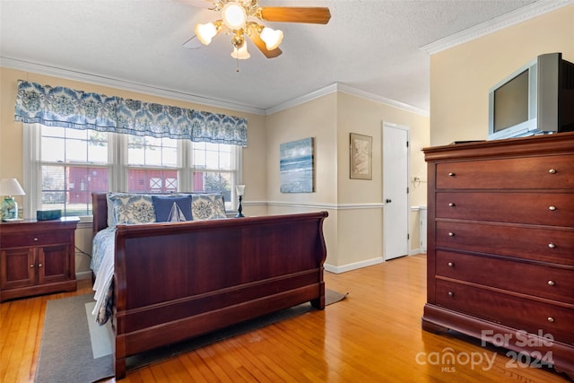 bedroom with ceiling fan, ornamental molding, a textured ceiling, and light hardwood / wood-style flooring