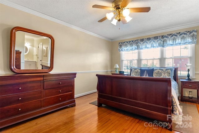 bedroom featuring ensuite bath, ceiling fan, light hardwood / wood-style floors, a textured ceiling, and ornamental molding