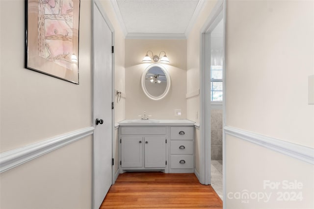 bathroom with vanity, ornamental molding, and hardwood / wood-style flooring