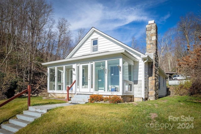 view of front of house featuring a front yard and a sunroom