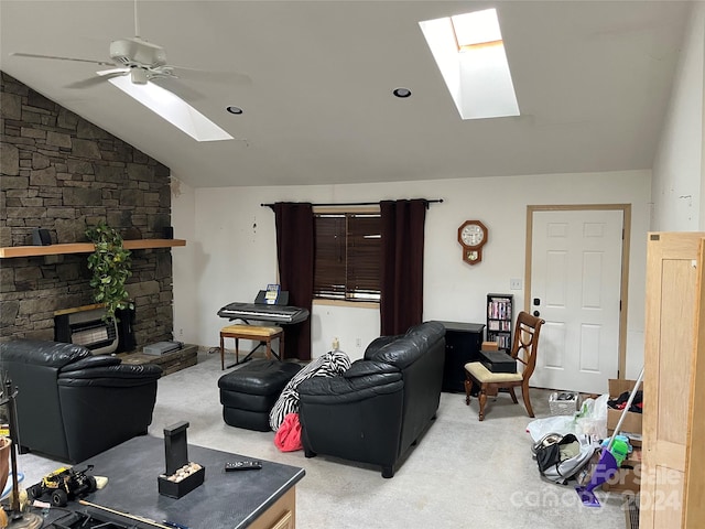 carpeted living room with a fireplace, lofted ceiling with skylight, and ceiling fan