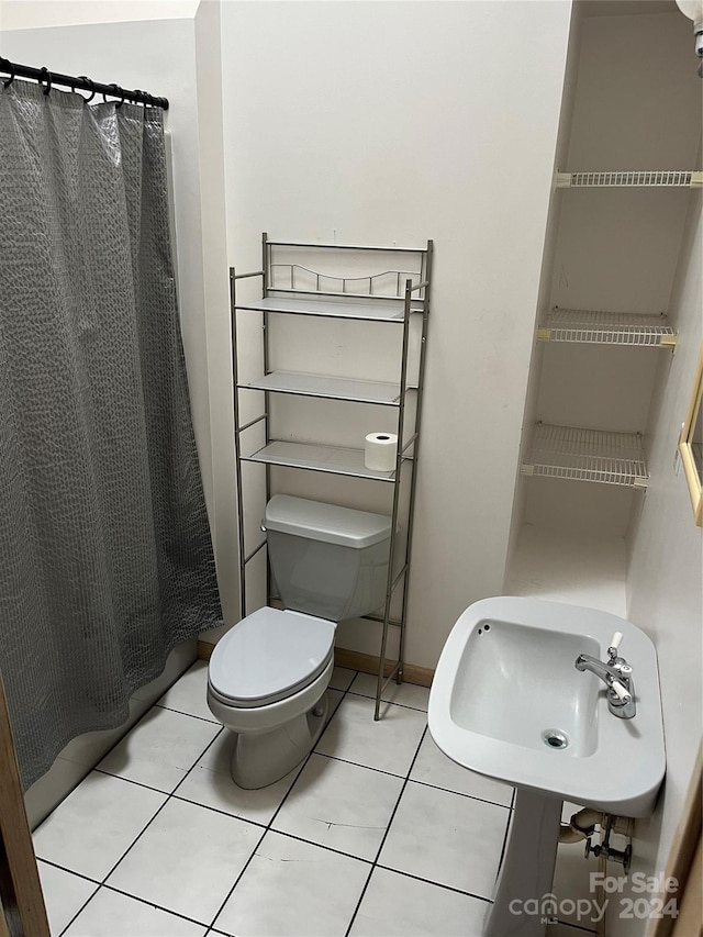 bathroom with walk in shower, tile patterned flooring, and toilet