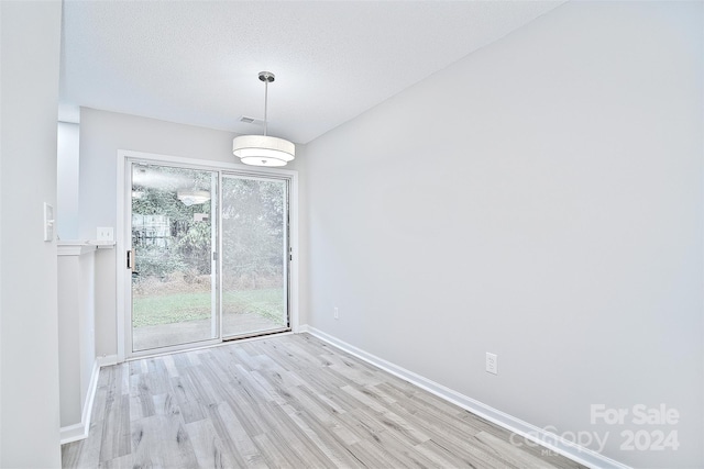 spare room featuring a textured ceiling and light wood-type flooring