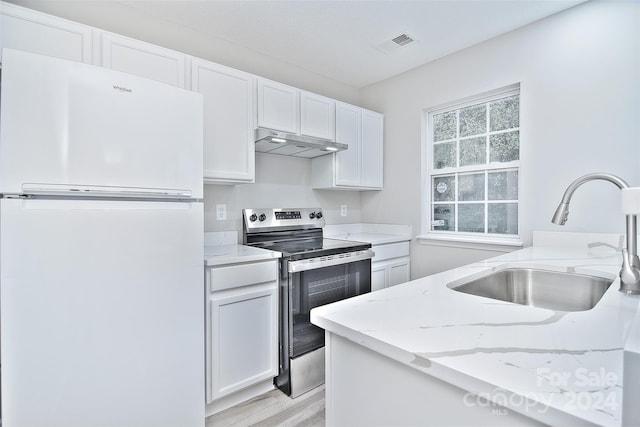 kitchen with white refrigerator, light hardwood / wood-style flooring, electric range, light stone countertops, and white cabinetry