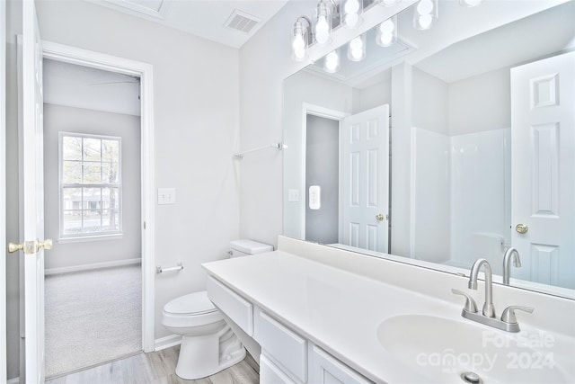 bathroom with a shower, wood-type flooring, vanity, and toilet