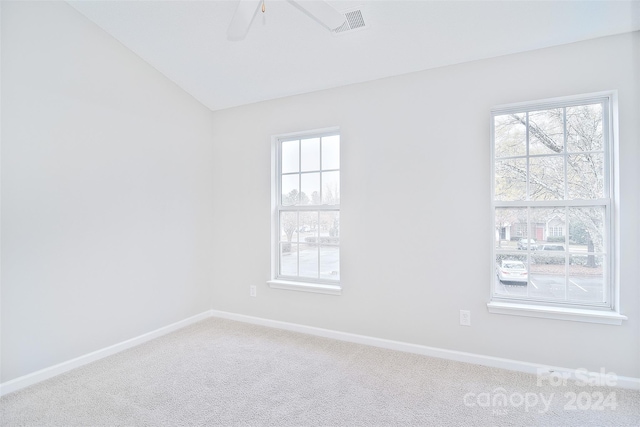 unfurnished room with a wealth of natural light, carpet floors, lofted ceiling, and ceiling fan