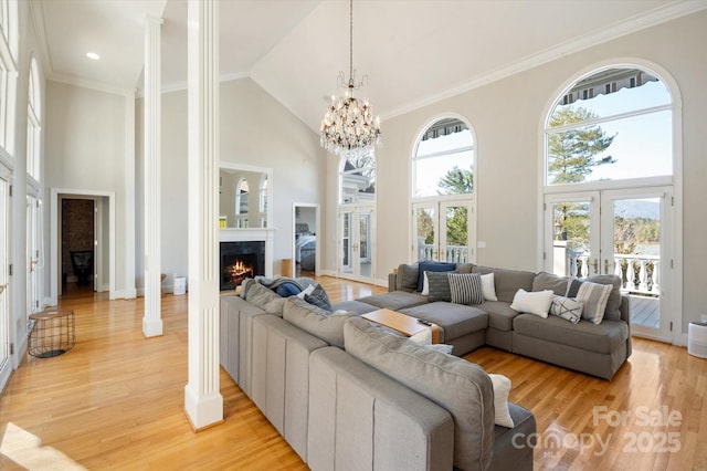 living room with high vaulted ceiling, light wood-type flooring, and french doors