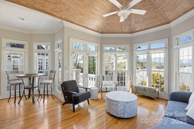 sunroom with lofted ceiling, wooden ceiling, ceiling fan, and french doors