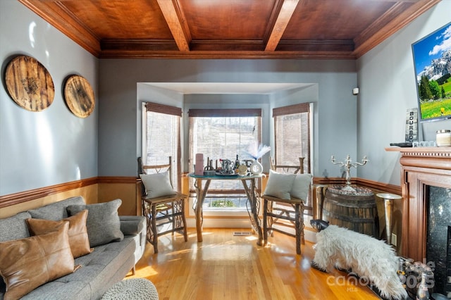 living area with a premium fireplace, ornamental molding, wood ceiling, and light hardwood / wood-style flooring