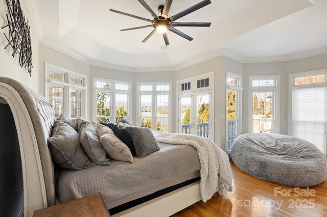 bedroom featuring french doors, wood-type flooring, crown molding, and access to outside