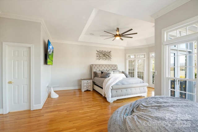 bedroom featuring ceiling fan, ornamental molding, a raised ceiling, and hardwood / wood-style floors