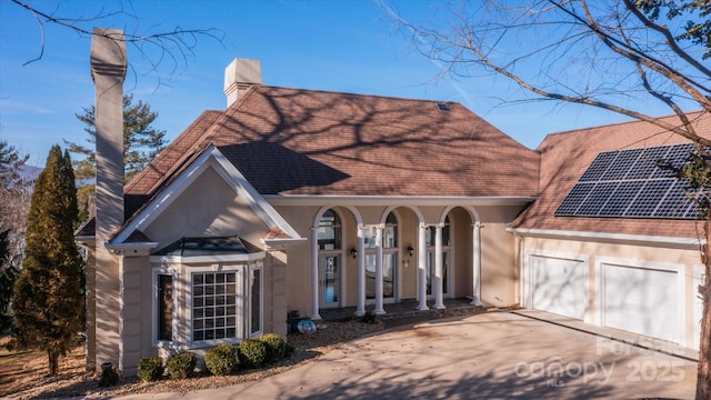 view of front of home with a garage and solar panels