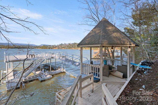 view of dock with a gazebo and a water view