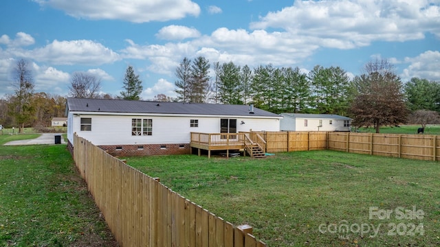 rear view of house with a lawn and a wooden deck