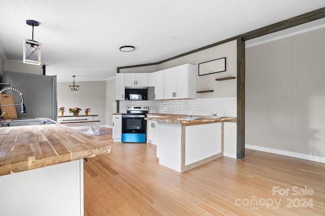 kitchen featuring white cabinetry, stainless steel appliances, wood counters, light hardwood / wood-style floors, and pendant lighting