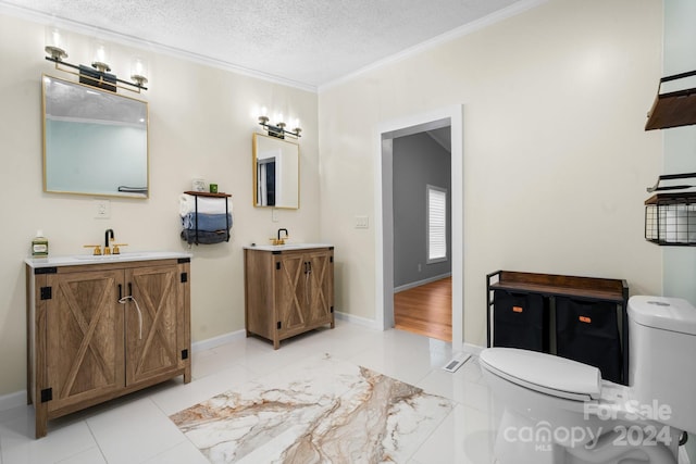 bathroom featuring tile patterned floors, vanity, a textured ceiling, crown molding, and toilet