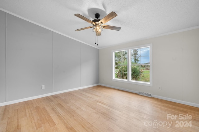 empty room with ceiling fan, light hardwood / wood-style floors, ornamental molding, and a textured ceiling